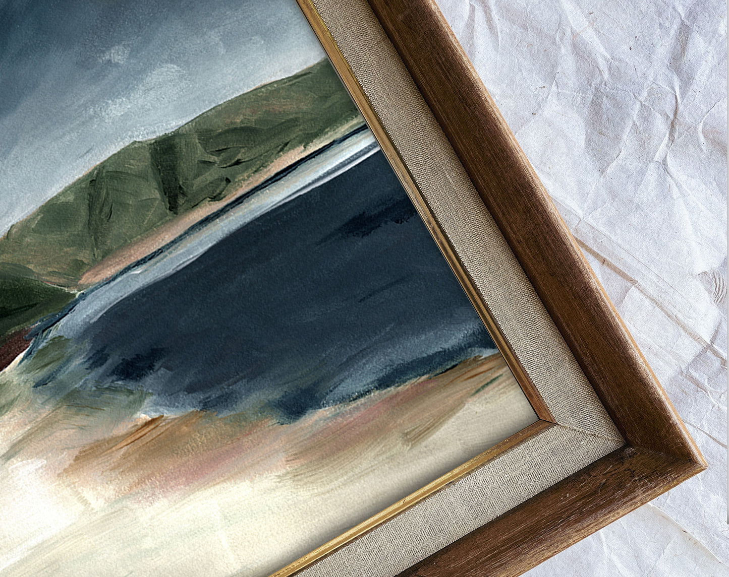 Framed painting of a landscape with mountains and water on a textured white surface