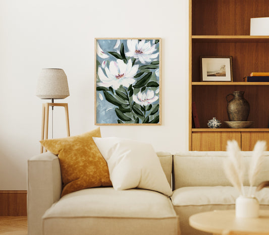 Living room with a beige sofa, floral artwork on the wall, and wooden shelves.