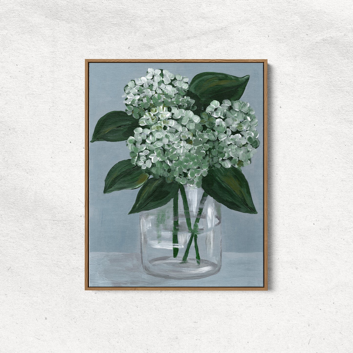 Framed artwork of white flowers in a glass vase on a textured wall.