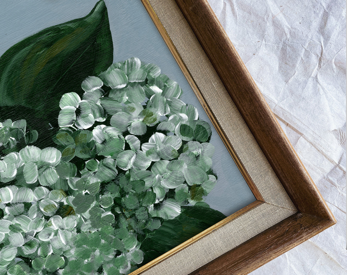 Framed artwork of green leaves on a textured surface