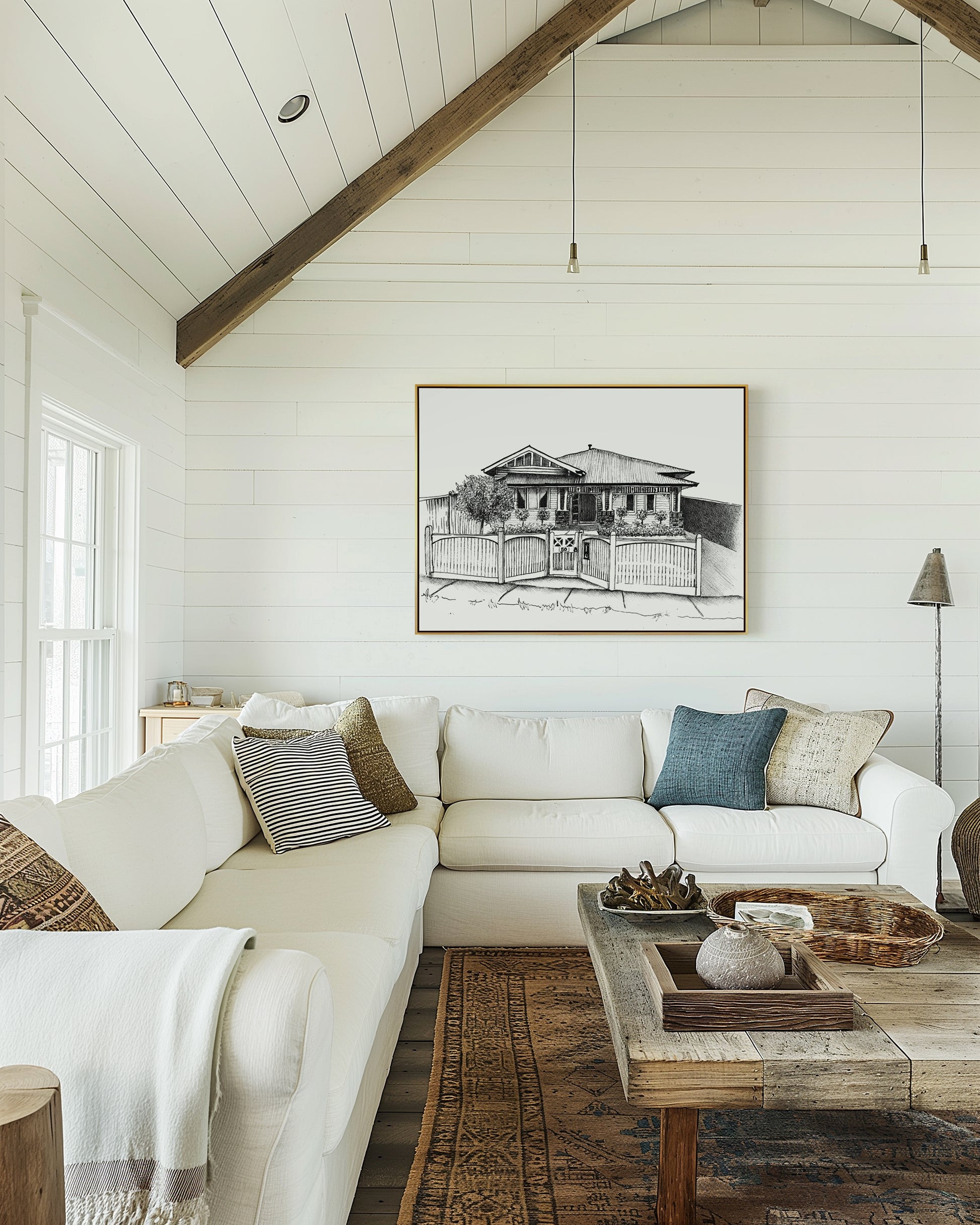 Cozy living room with a white sofa, wooden coffee table, and framed artwork on the wall.