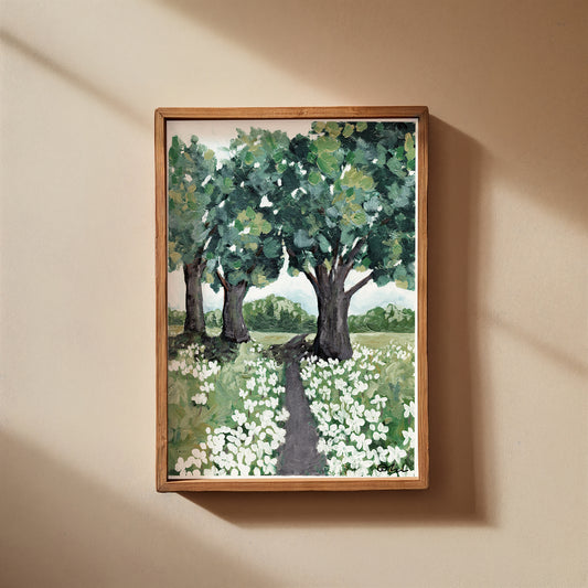 Framed painting of a landscape with trees and flowers on a beige wall.